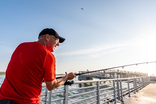 Senior man fishing at sunrise